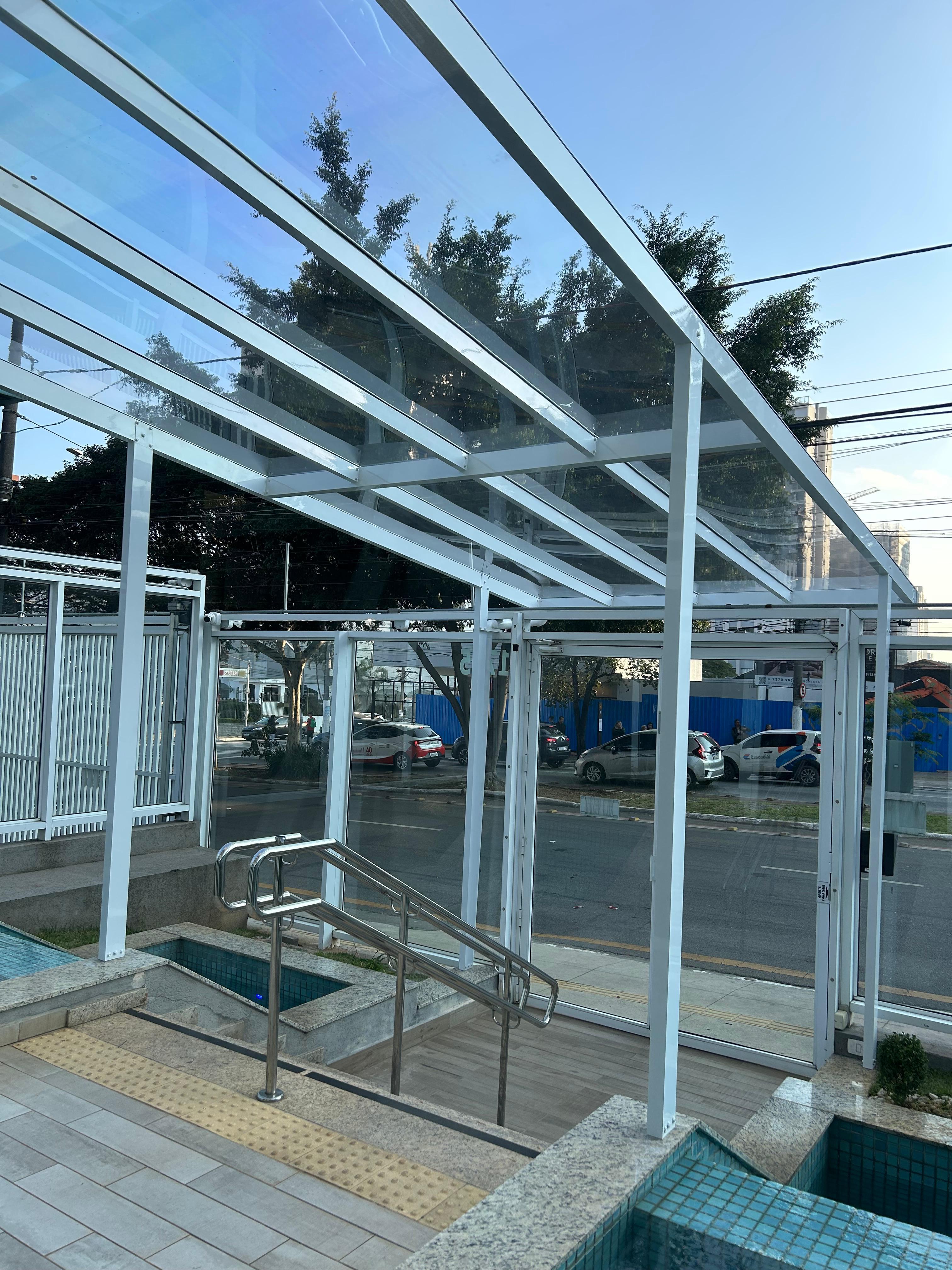 Cobertura fixa em policarbonato transparente sobre área com piscina